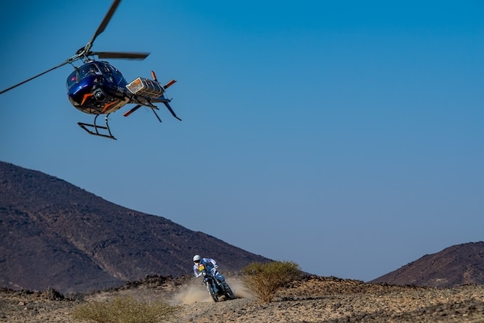Dakar motorbike rider followed by helicopter