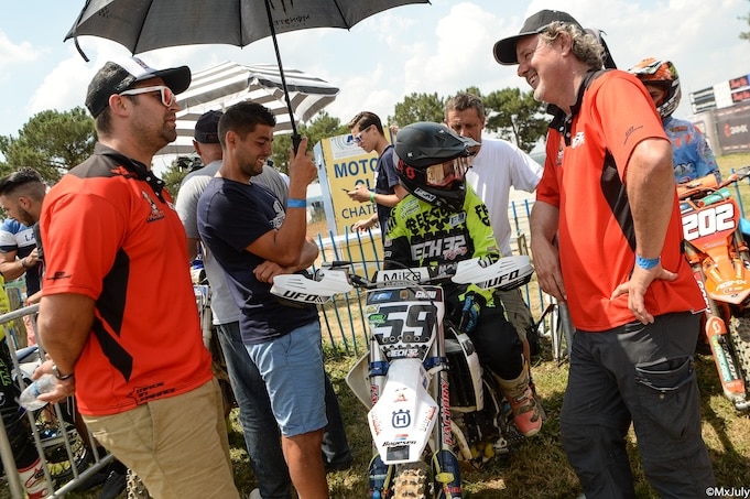 A rider on his motocross bike and his team of mechanics 
