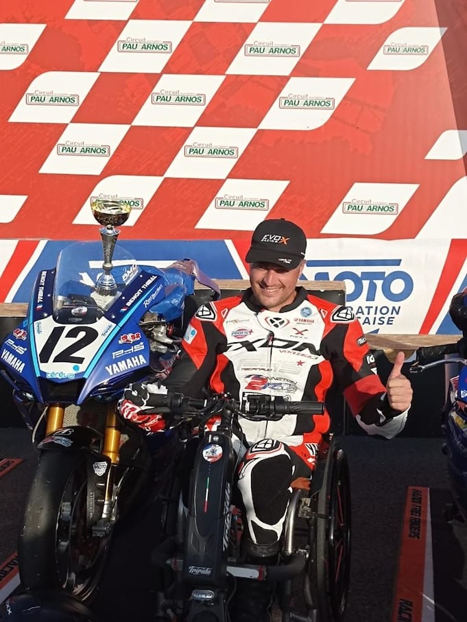 Athlète PMR sur un podium de course moto Handisport