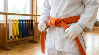 Pratiquant attachant une ceinture orange de karaté