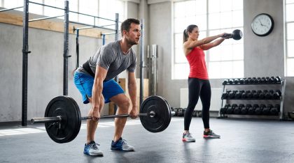 Homme soulevant une barre de musculation et femme réalisant un exercice avec kettlebell dans une salle de sport
