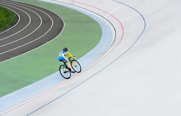 femme avec un velo sur piste qui roule