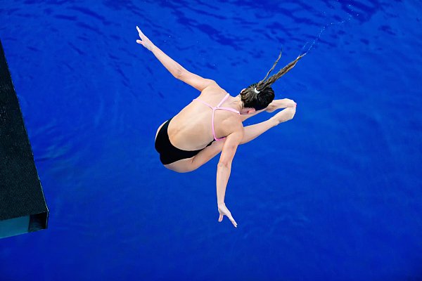 Vue d'angle élevé d'une femme avec les bras tendus plongeant dans une piscine