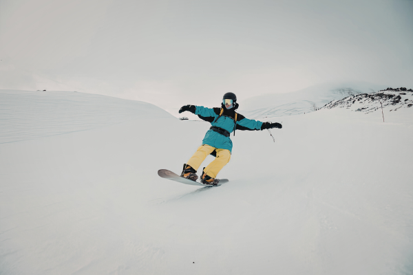 homme sur son snowboard sur une piste en montagne